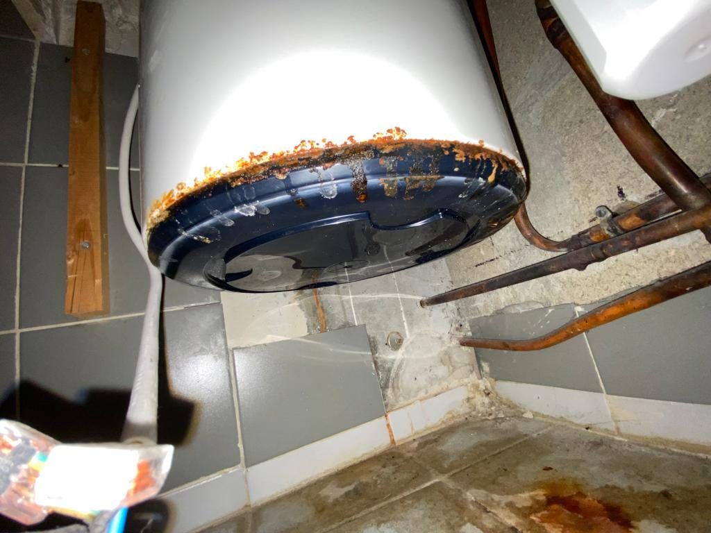 Chauffe-eau électrique rouillé et percé en partie basse, fuite constatée par La Tuyauterie Française en Île-de-France
