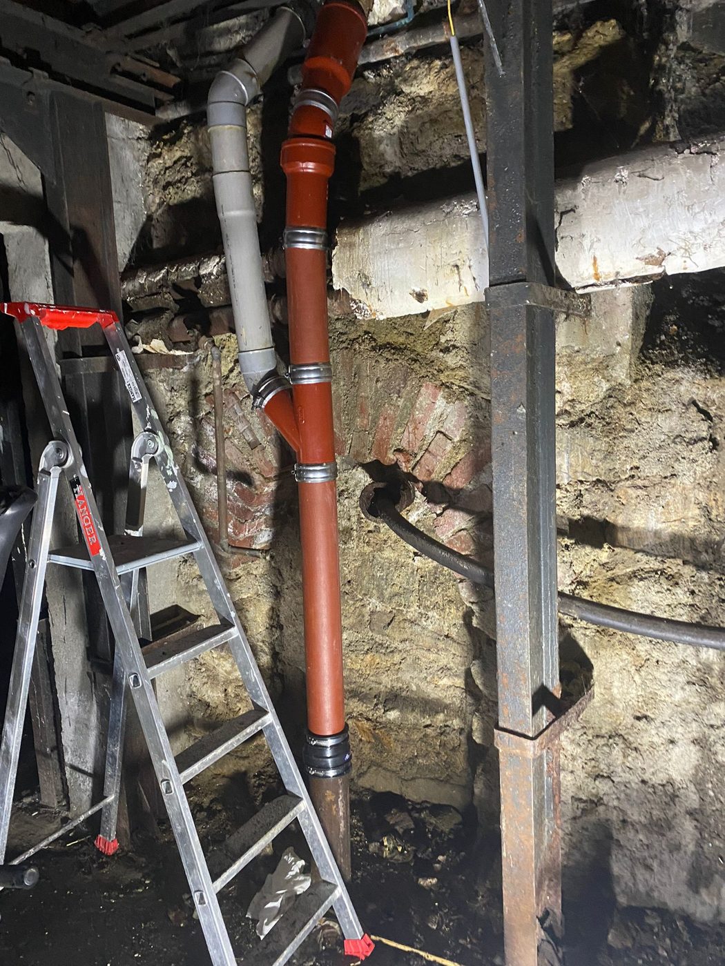 Remplacement d'une colonne d'évacuation en fonte par du PVC en cave d'immeuble parisien, La Tuyauterie Française