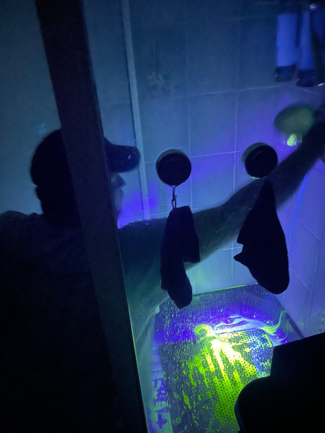 Détection de fuite à la fluorescéine sous lampe UV dans une salle de bain, La Tuyauterie Française en Île-de-France