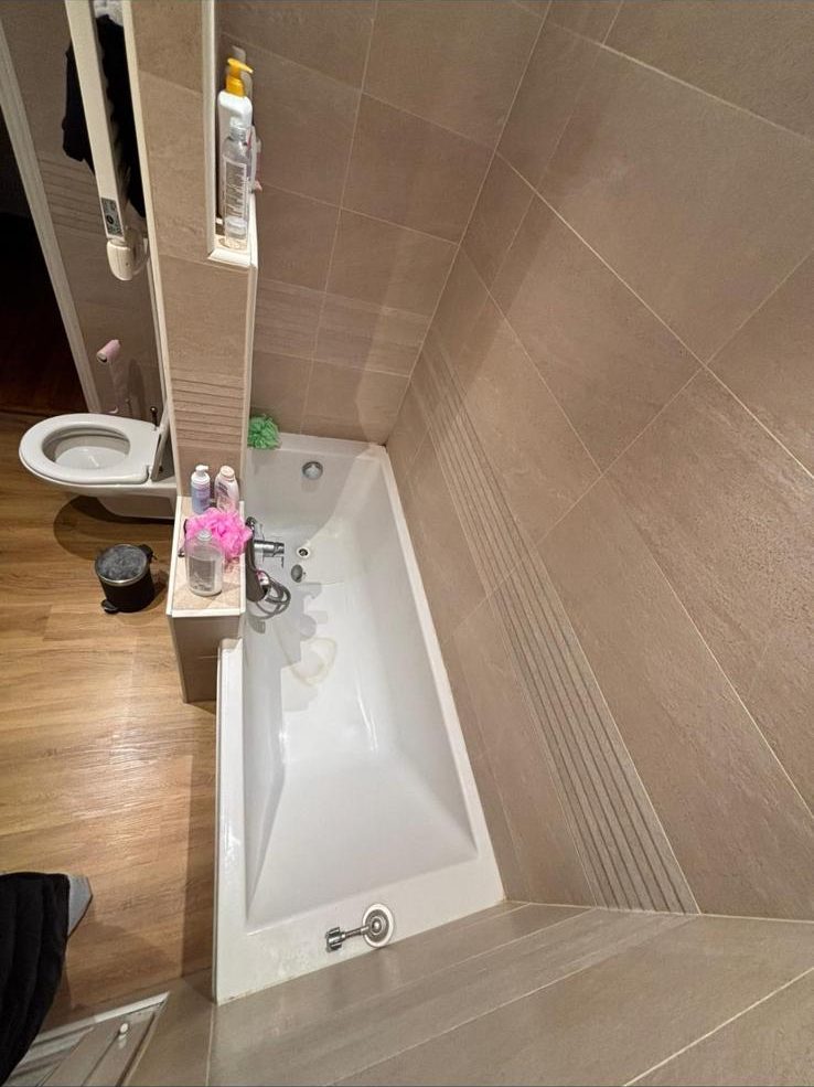 Baignoire encastrée avec tablier carrelé, siphon situé sous la baignoire